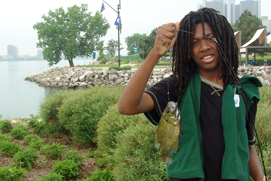 Kid holding a fish from fishing pole