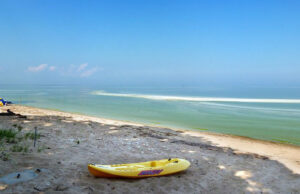 kayak sitting on beach with algal bloom on Lake Erie
