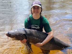 researcher holding a lake sturgeon caught during sampling