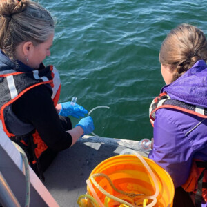two researchers on a boat working on a project