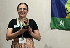 Meaghan Gass holds her award in the form of an owl, from MSTA.