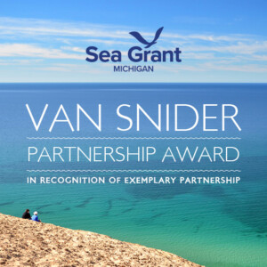 Image of an award that is given that depicts a blue-green Lake Michigan from Sleeping Bear Dunes National Lakeshore, with the words 