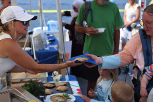 Visitors receive a fish pasty from a tasting demonstration at the fish fry. Photo: Monte Consulting
