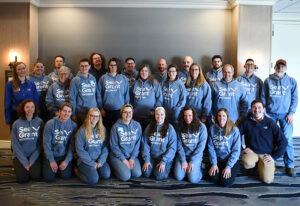 A group photo of staff wearing a Sea Grant hoodie
