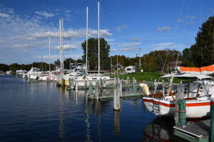 a marina with sail boats and recreation boats on a day with a blue sky