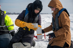 Researchers collect water samples from underneath the ice of Lake St. Clair