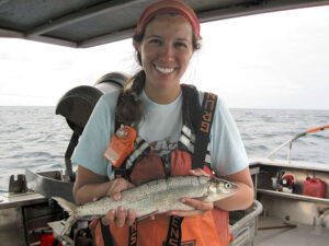 A researcher holds a lake whitefish on a Great Lake