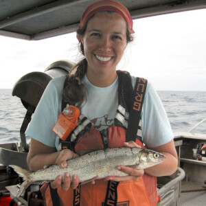 A researcher holds a lake whitefish on a Great Lake