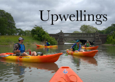 Upwellings newsletter June 2025 cover with several orange kayaks in a Detroit River canal with a bridge in the background