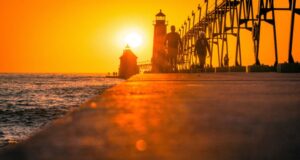 A orange toned sunset over a pier on lake michigan