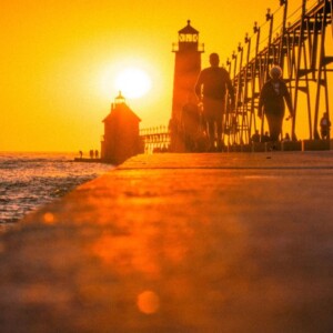 A orange toned sunset over a pier on lake michigan