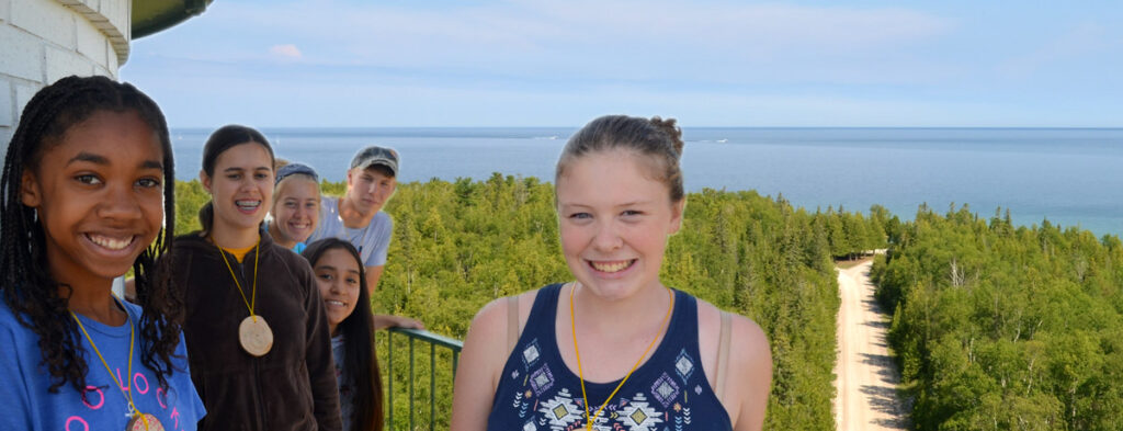 campers posing for a photo at the top of a lighthouse along lake huron