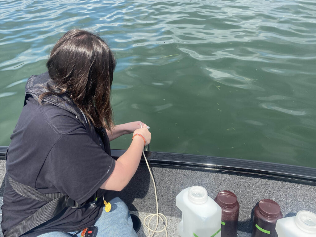 A researcher samples water for the HABs grab 2025