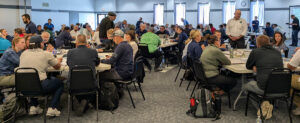 A large meeting room with people having discussions at tables