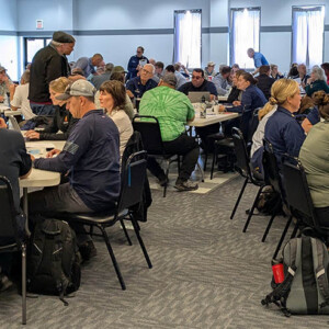 A large meeting room with people having discussions at tables