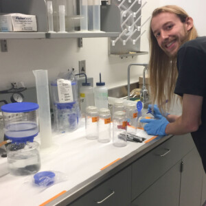 A scientist in a lab working on a study with lab equipment on a table