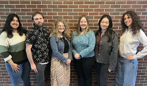 6 project team members stand in front of a brick wall